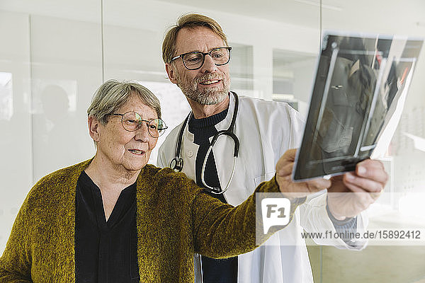 Doctor discussing x-ray image with senior patient