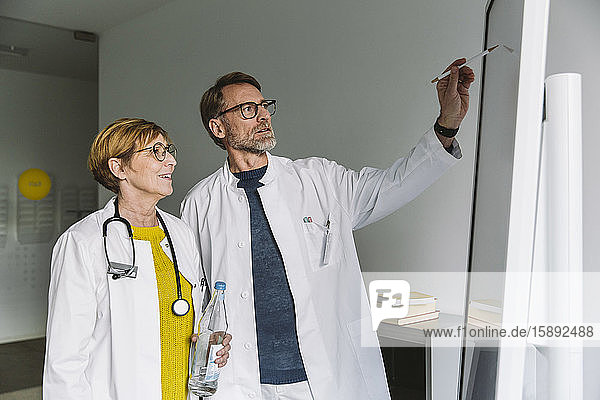 Two doctors discussing at smart board