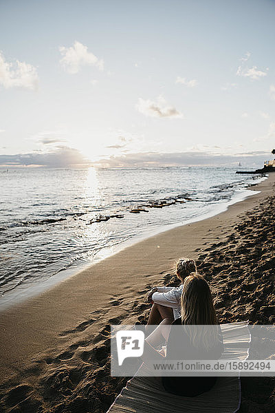 Hochwinkelaufnahme von Freunden  die im Sommer in Hawaii  Oahu  USA  am Strand sitzen