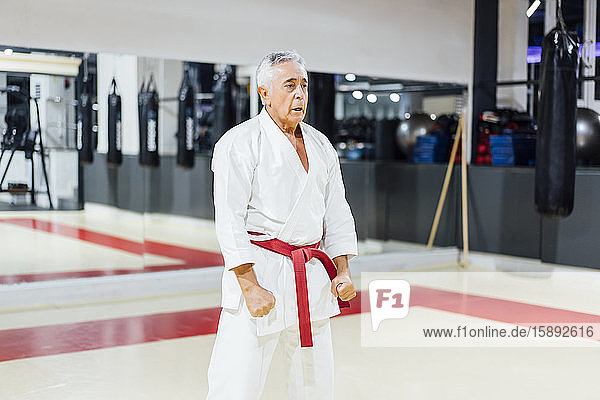 Senior man practicing karate in gym