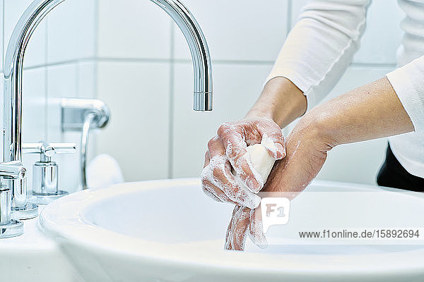 Frau wäscht ihre Hand mit Seife