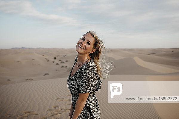 Porträt einer glücklichen blonden Frau auf einer Sanddüne stehend  Algodones Dunes  Brawley  USA