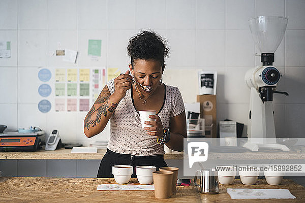 Frau arbeitet in einer Kaffeerösterei und verkostet ein Produkt