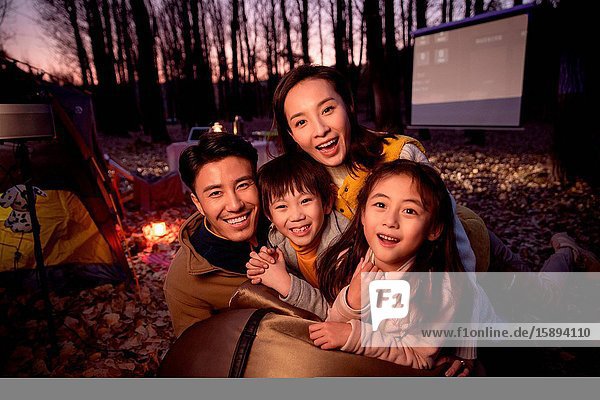 Happy family night camping in the wilderness