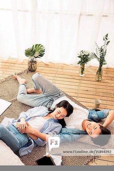 Happy lovers lying on the carpet to enjoy an afternoon
