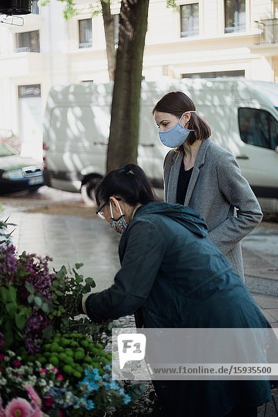 Woman with mask buying flowers.