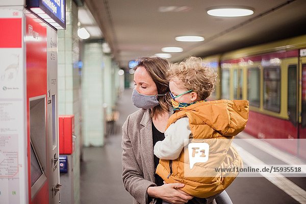 Mother and son taking public transportation with mask during Corona days.