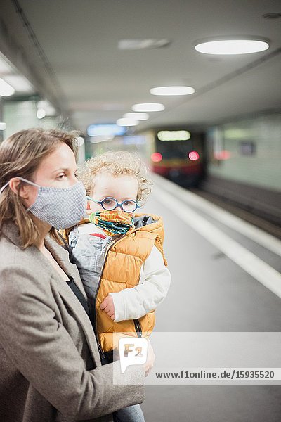 Mother and son taking public transportation with mask during Corona days.