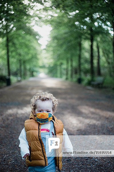 Little boy 2-3 Years old wih mask in the park.