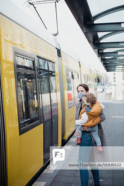Mother and son taking public transport with mask during corona days.