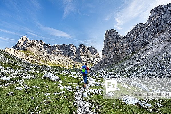 Wanderer  Bergsteiger auf einem Wanderweg zwischen felsigem Gebirge am Forcella Grande  Sorapiss Umrundung  hinten Berg Punte Tre Sorelle  Dolomiten  Belluno  Italien  Europa