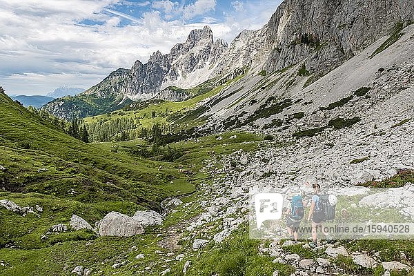 Zwei Wanderer auf markiertem Wanderweg von der Adamekhütte zur Hofpürglhütte  Ausblick auf Bergkamm mit Berggipfel Große Bischofsmütze  Salzkammergut  Oberösterreich  Österreich  Europa