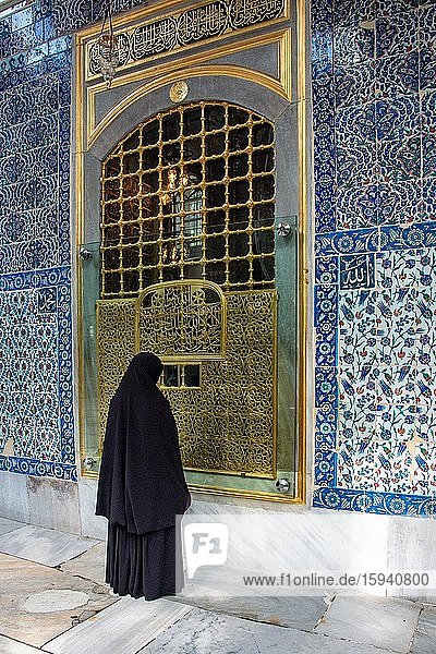Gläubige verschleierte Frau betet vor einem goldenen Tor  Istanbul  Türkei  Asien