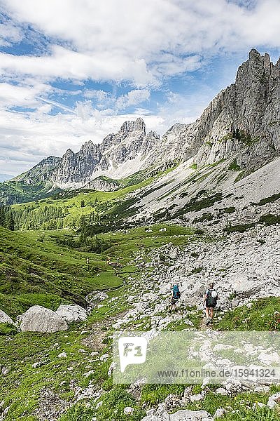Zwei Wanderer auf markiertem Wanderweg von der Adamekhütte zur Hofpürglhütte  Ausblick auf Bergkamm mit Berggipfel Große Bischofsmütze  Salzkammergut  Oberösterreich  Österreich  Europa