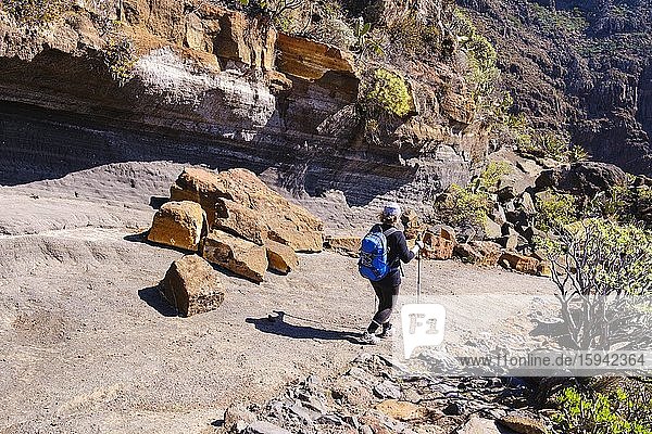 Woman hiking on rocky trail  Alto de Tacalcuse  near San Sebastian  La Gomera  Canary Islands  Spain  Europe