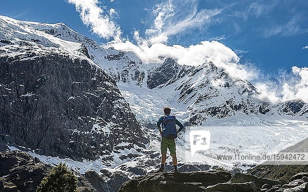 Mountaineer stands on rocks  impressive view of Rob Roy Glacier  Mount Aspiring National Park  Otago  South Island  New Zealand  Oceania