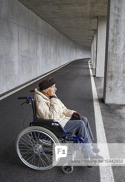Seniorin im Rollstuhl in einer Unterführung  Österreich  Europa
