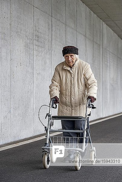 Senior citizen with walker walks in an underpass  Austria  Europe