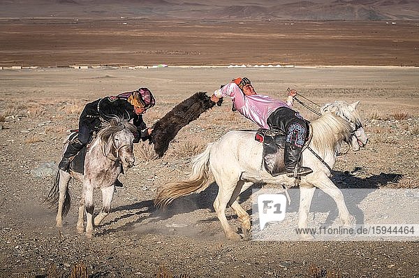 Zwei Kasachen auf Pferden beim traditionellen Spiel Kokbar  Provinz Bajan-Ölgii  Mongolei  Asien
