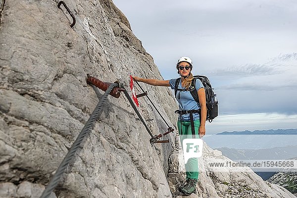 Bergsteigerin auf gesicherter Route an steiler Felswand  Weg von Simonyhütte zur Adamekhütte  felsiges alpines Gelände  Salzkammergut  Oberösterreich  Österreich  Europa