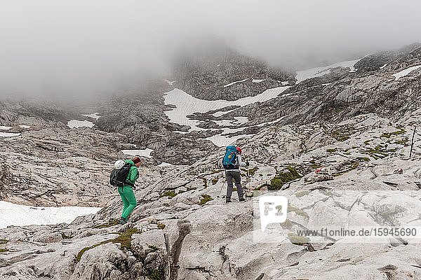 Zwei Bergsteigerinnen auf markiertem Route von Simonyhütte zur Adamekhütte  felsiges alpines Gelände mit Schneeresten  Salzkammergut  Oberösterreich  Österreich  Europa