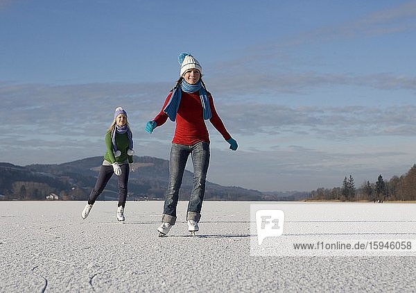 Young happy girls  teenagers skating at the lake  Irrsee  Salzkammergut  Upper Austria  Austria  Europe