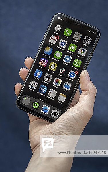 Hand hält iPhone  Smartphone  Display mit verschiedenen Apps  Deutschland  Europa