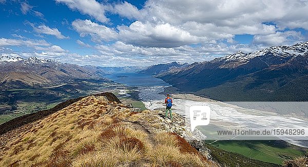 Hiker on the summit of Mount Alfred  views of Lake Wakatipu and mountain scenery  Glenorchy near Queenstown  Southern Alps  Otago  South Island  New Zealand  Oceania