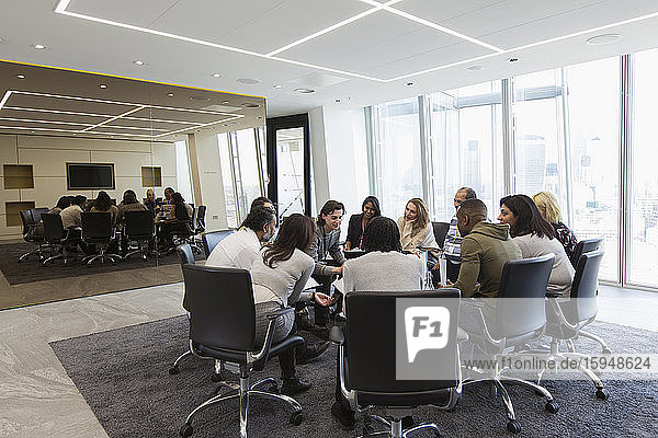 Business people meeting in circle in conference room