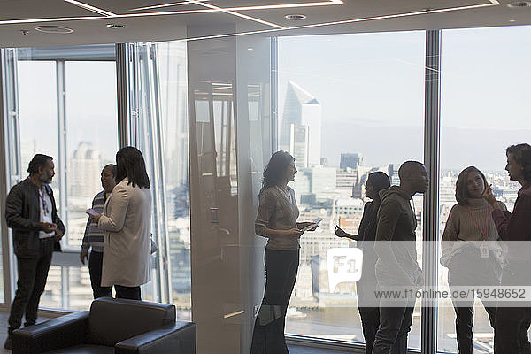 Business people talking at highrise office window