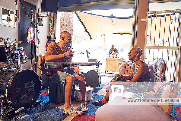 Musicians talking and practicing in garage recording studio