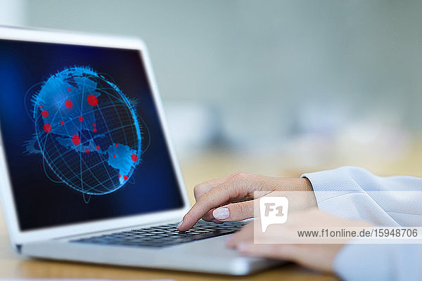 Wissenschaftlerin betrachtet globale Pandemieausbrüche am Laptop