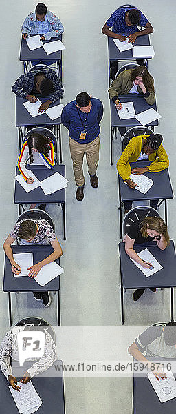 Blick von oben auf den Gymnasiallehrer  der die Schüler bei der Prüfung beaufsichtigt