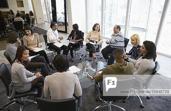 Business people talking in circle in conference room meeting
