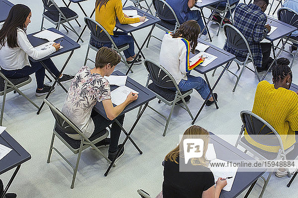 Gymnasiasten  die an Schreibtischen im Klassenzimmer Prüfungen ablegen