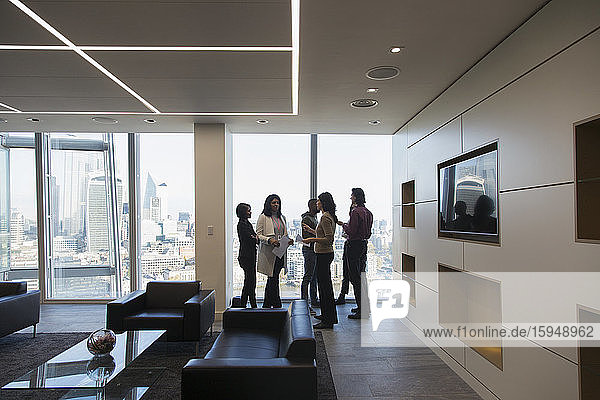 Business people talking in modern highrise office lobby