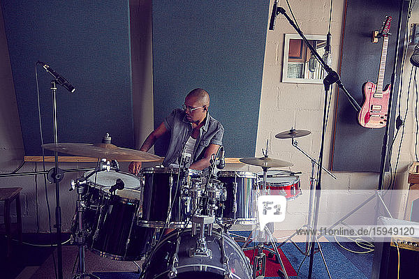 Männlicher Schlagzeuger beim Üben im Aufnahmestudio
