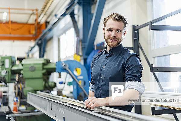 Portrait of a smiling young man in a factory