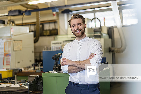 Portrait of a smiling young man in a factory