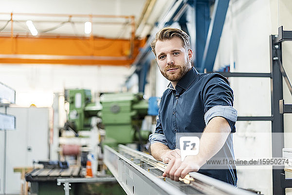 Portrait of a confident young man in a factory