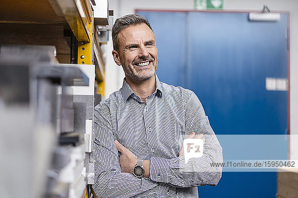 Porträt eines glücklichen Geschäftsmannes in einer Fabrik