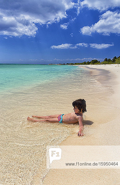 Mädchen ohne Hemd spielt in den Sommerferien am Strand am Meeresufer  Punta Sur  Cozumel  Mexiko