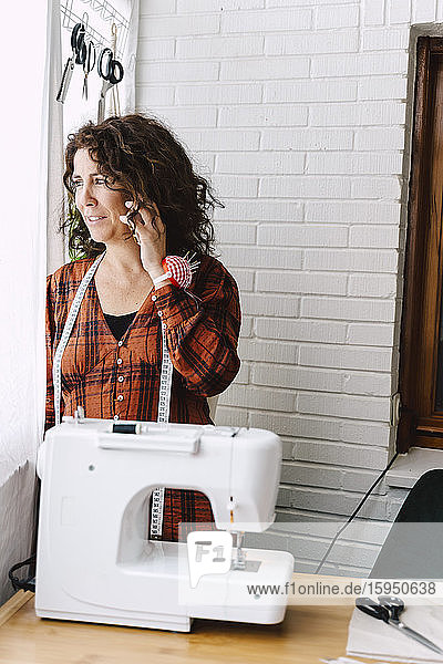 Woman with sewing machine on the phone