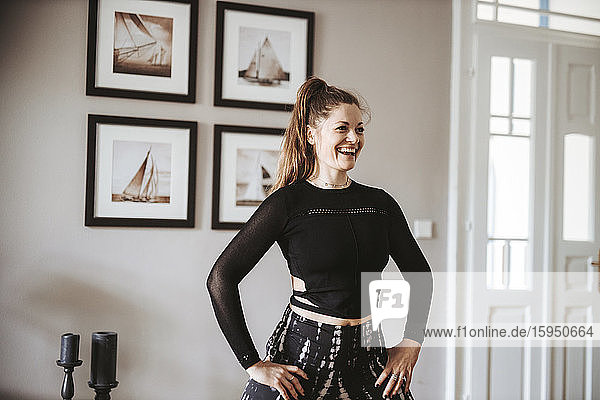 Porträt einer lachenden Frau  die zu Hause Yoga praktiziert