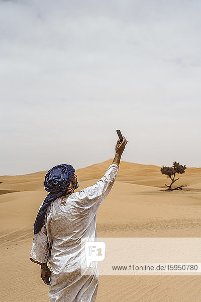 Mann nimmt Smartphone-Selfie in die Wüste