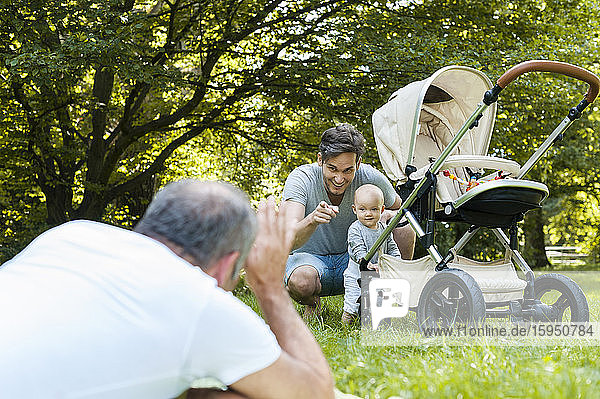 Senior man spending time with his adult son and his granddaughter in a park