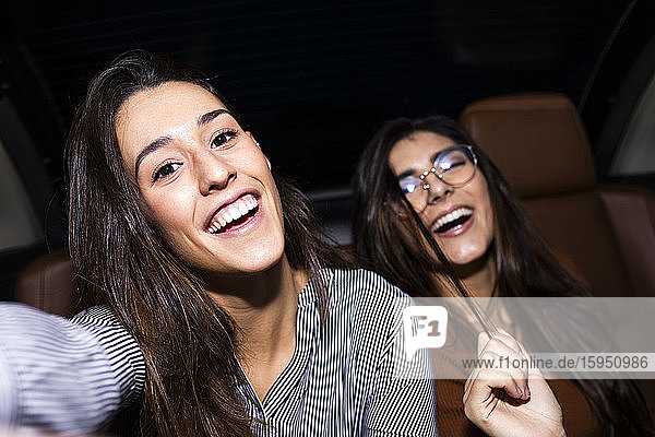 Portrait of happy friends enjoying in convertible car during road trip