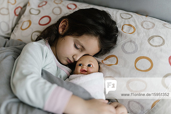 Sleeping little girl with her doll
