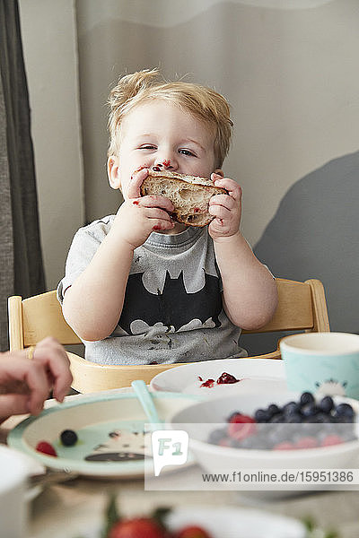 Porträt eines verschmierten kleinen Jungen  der Brot mit Marmelade isst