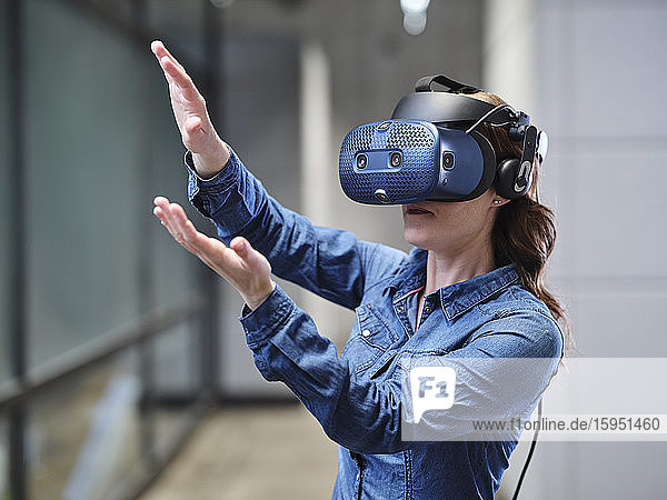 Frau mit VR-Brille und Headset im modernen Büro